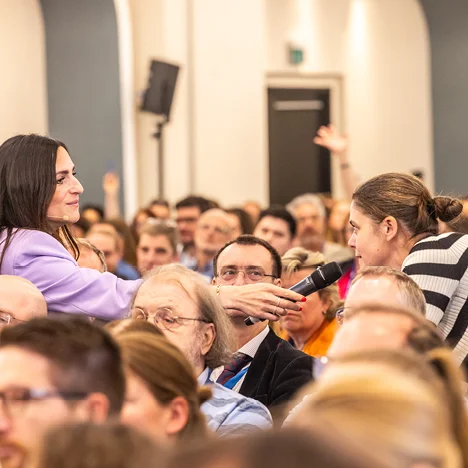 Moderatorin im Publikum mit Mikrofon