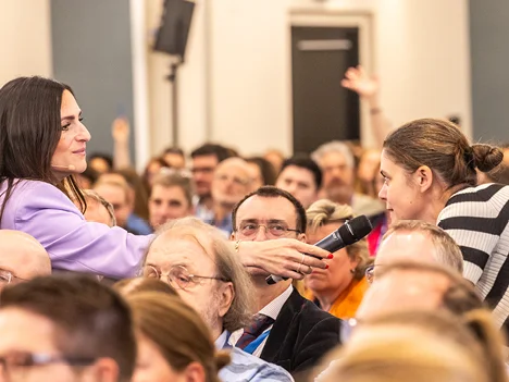 Moderatorin im Publikum mit Mikrofon